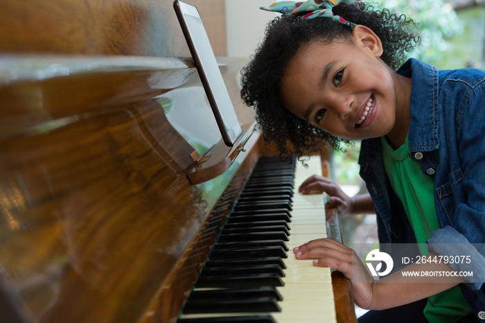 Girl playing piano with digital tablet