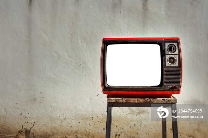 Vintage old TV cut out screen on a wooden bench in front of old white wall