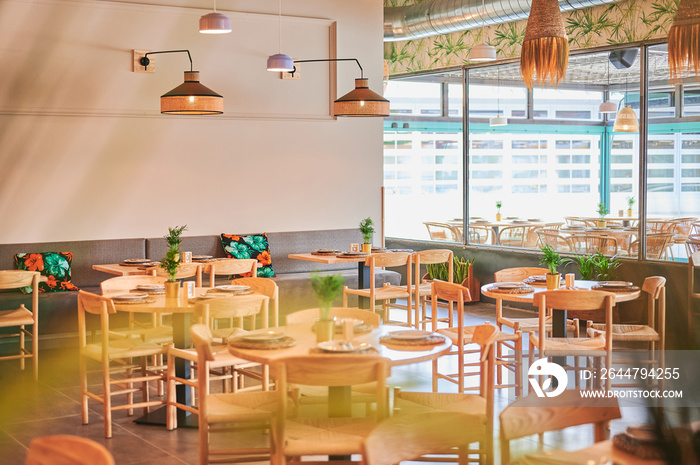 empty rustic design restaurant with wooden furniture with some front defocused plants