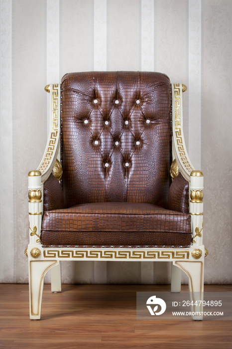 Brown and gold chair with wallpaper background