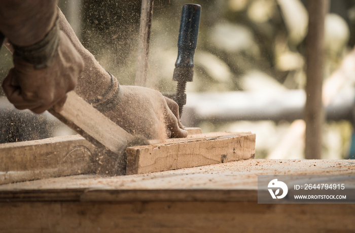 Handmade and craft furniture concept: Carpenter engaged in processing wood at the sawmill