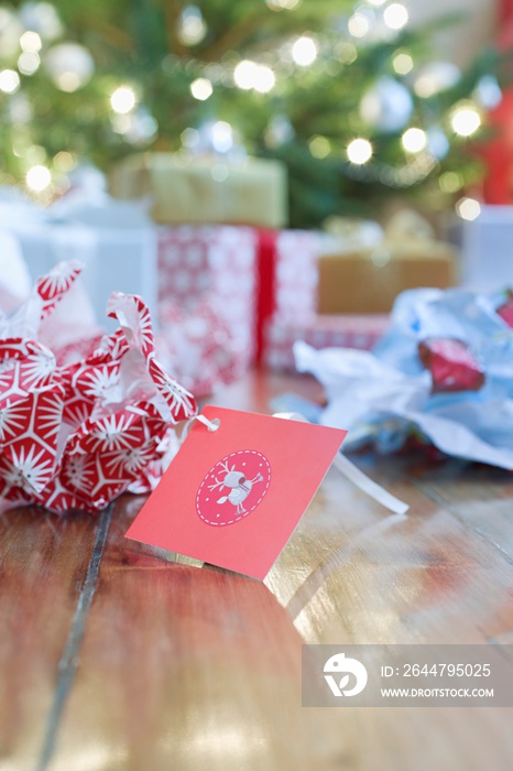 Unwrapped Gift Paper And Tag On Hardwood Floor