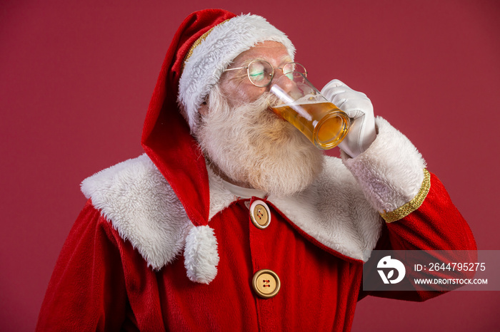 Santa Claus drinking a glass of beer. Rest time. Alcoholic drink at the holidays. Drink with moderat