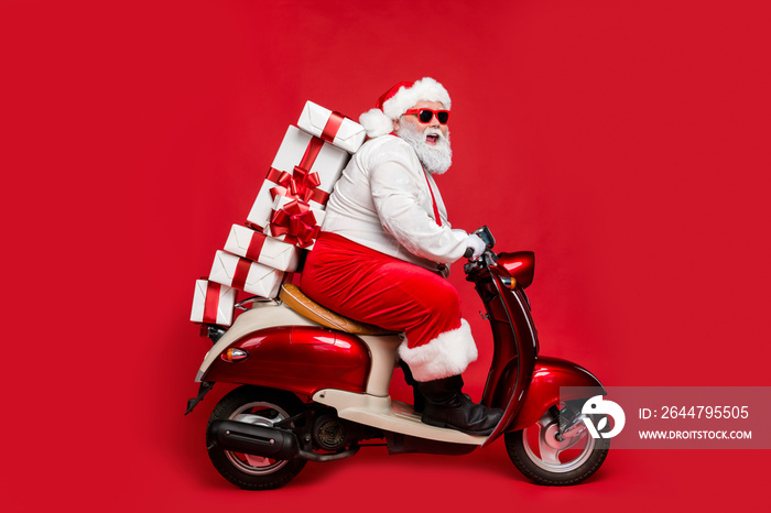 Profile side view portrait of nice bearded cheerful cheery funny funky Santa riding moped hurry up d