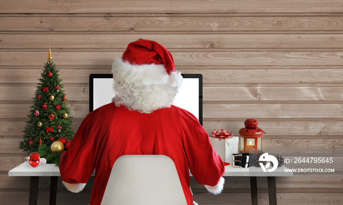 Santa Claus work on a computer in his office. Answer on letters and greeting cards via email. Free s