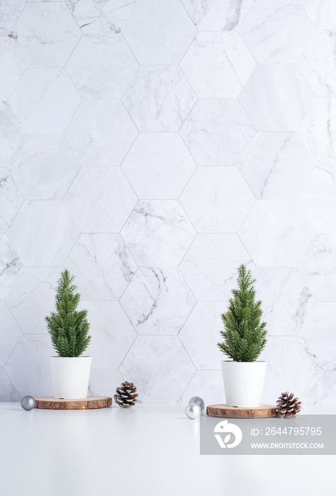 christmas tree with pine cone,decor xmas ball on wood log at white table and marble tile wall backgr