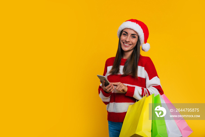 Close up photo of happy cute smiling young trendy woman in a Christmas red hat with many colorful sh