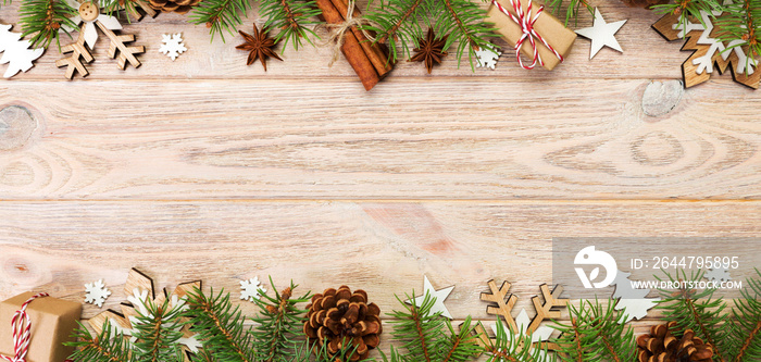 Christmas background with fir tree and gift box on wooden table. Top view banner with copy space for