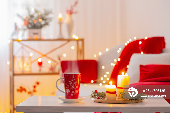 cup of hot drink with christmas decorations in white and red colors at home