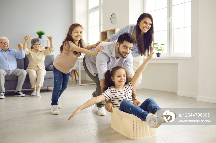 Happy European family celebrates the day of moving to a new apartment. Young parents and elderly gra