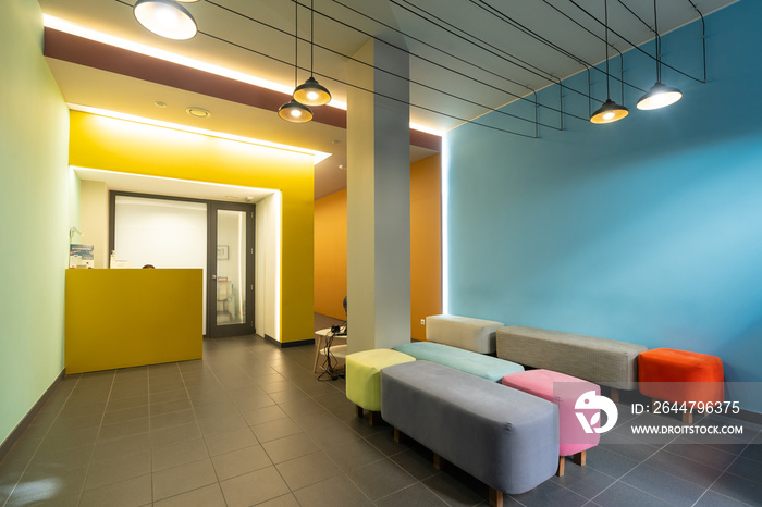 Waiting room of a modern dental clinic with colored sofas