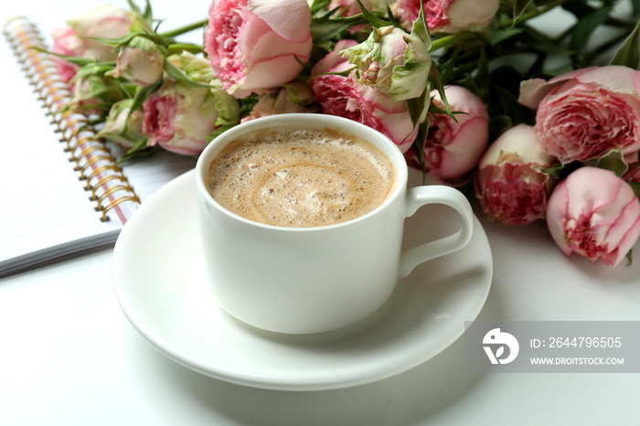 Roses, cup of coffee and copybook on white background