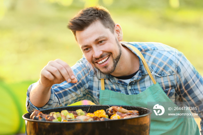 Man cooking tasty food on barbecue grill outdoors