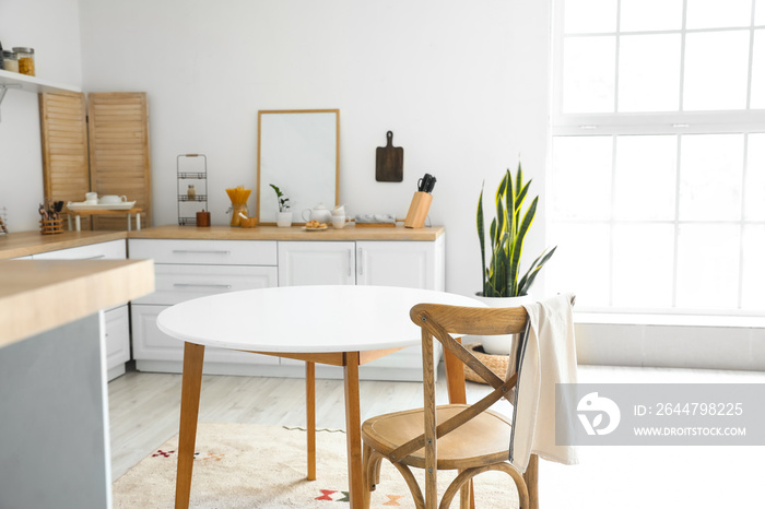 Modern kitchen interior with blank poster frame and light window