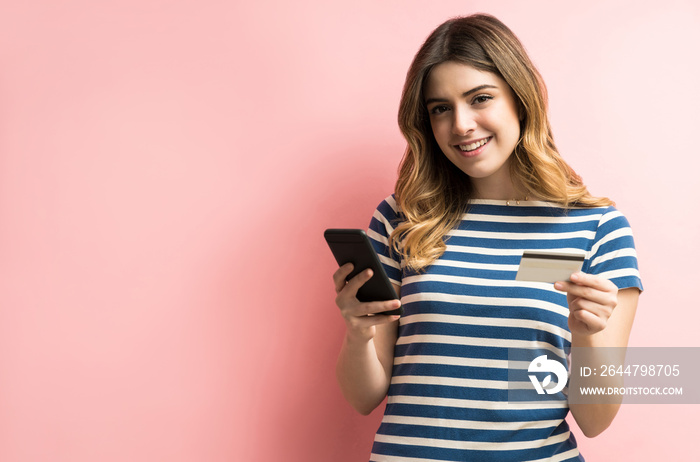 Beautiful Woman Doing Online Shopping Through Cellphone In Studio