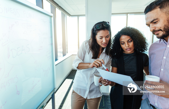 Woman entrepreneurs discussing business plan in boardroom.