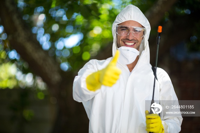 Man showing thumbs up while holding insecticide sprayer