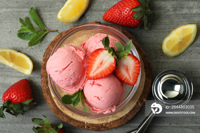 Bowl with ice cream balls and ingredients on gray textured background