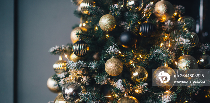 Christmas tree decorated with garlands and golden balls on a dark background