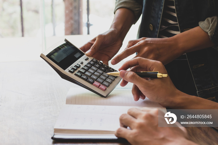 Asian young man and woman sitting pointing studying examining and using calculator tutor Math books 