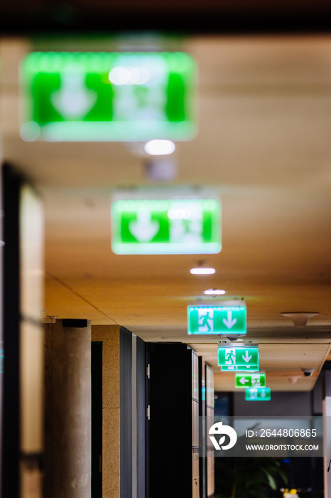 Green Exit Sign pointing to the nearest emergency exit in a modern office interior