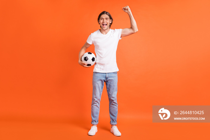 Full body photo of young cheerful happy man raise hand winner football isolated on orange color back
