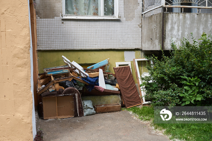 A large pile of rubbish under the Windows of a house