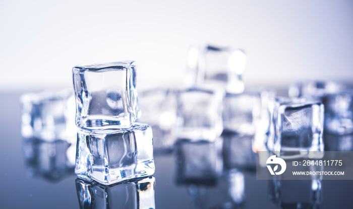 Three ice cubes on blue background.