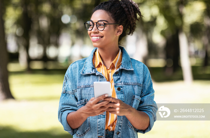 African Student Girl Using Cellphone Walking On Weekend In Park