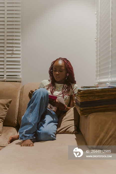 woman sitting on a sofa writing