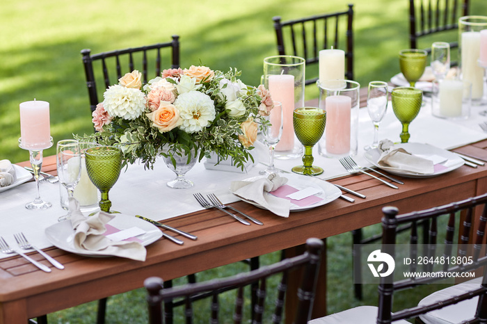 dinner tables with white tablecloth, served with porcelain and green glasses. Georgeous wedding tabl