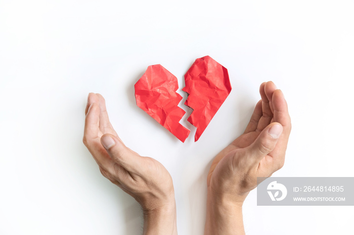 Red crumpled and broken heart shape paper and mans hand