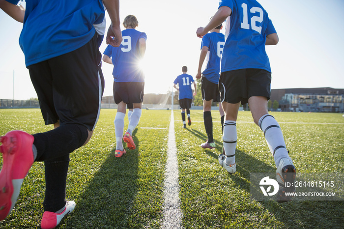 View from behind of soccer players running on field.