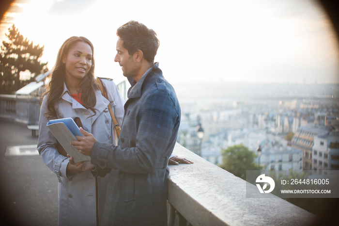 Couple with digital tablet on balcony overlooking Paris, France