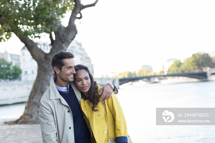 Affectionate couple walking along Seine River, Paris, France