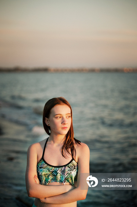 Thoughtful teenage girl standing by sea