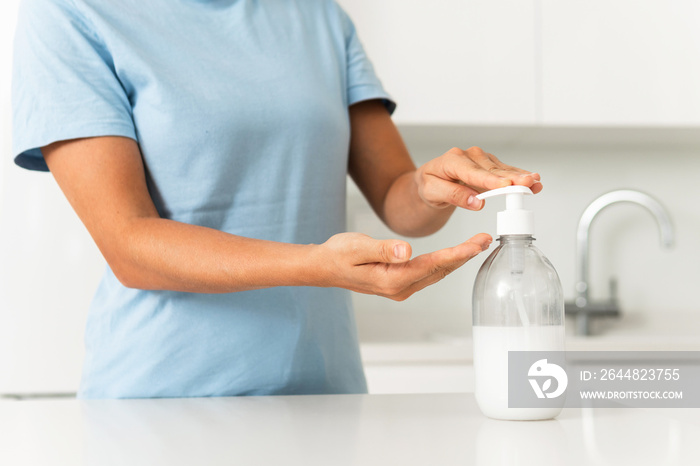 Woman using hand sanitizer or liquid soap for hands disinfection