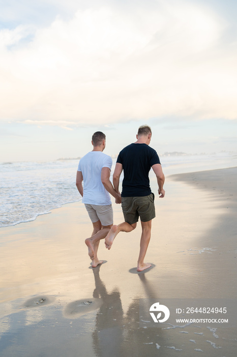 同性恋情侣在海滩上牵手逃跑
