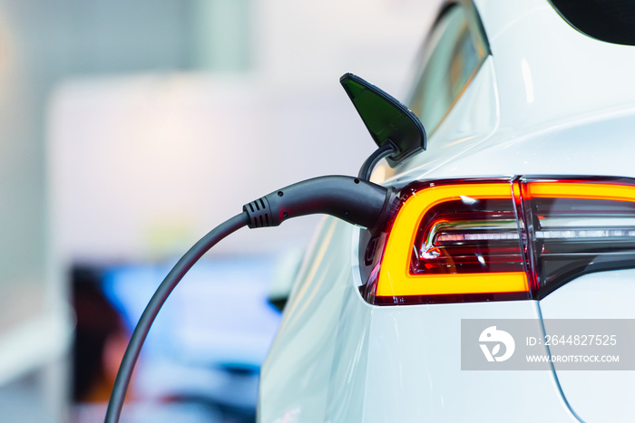 Close up of the Hybrid car electric charger station with power supply plugged into an electric car b