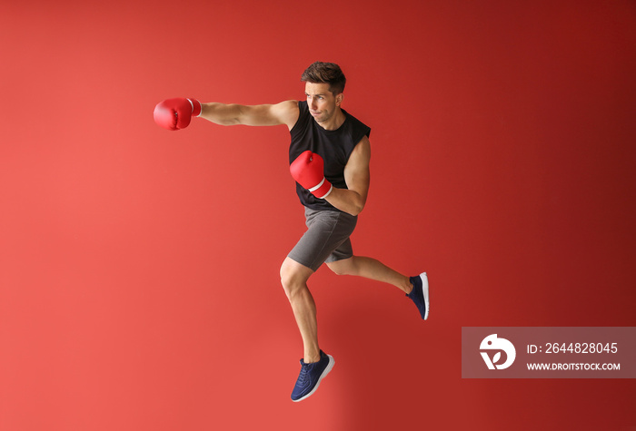 Sporty male boxer on color background