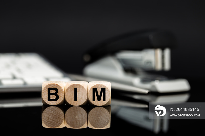 BIM - Würfel vor Büromaterial