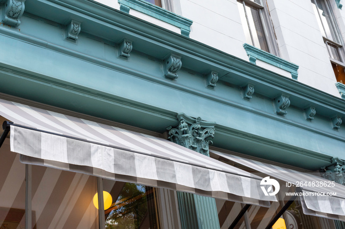 Detail of beautiful teal woodwork and boldly striped awnings create in interesting abstract composit