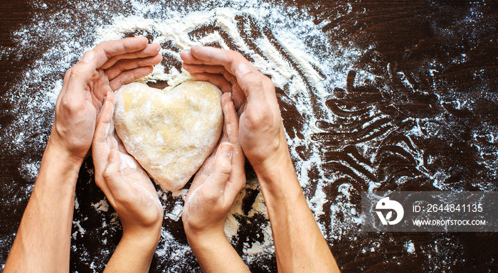 Hands of men and women make dough heart. The symbols of protecti