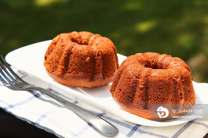 Small banana and dates bread Bundt cakes on a wooden background with copy space