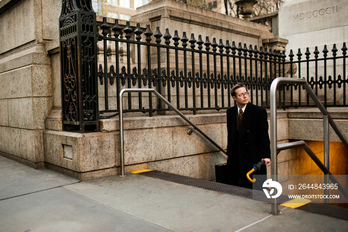 Businessman looking away while moving up steps