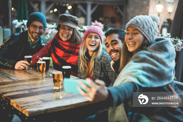 Young people having fun doing selfie at pub restaurant - Soft focus on center girl face