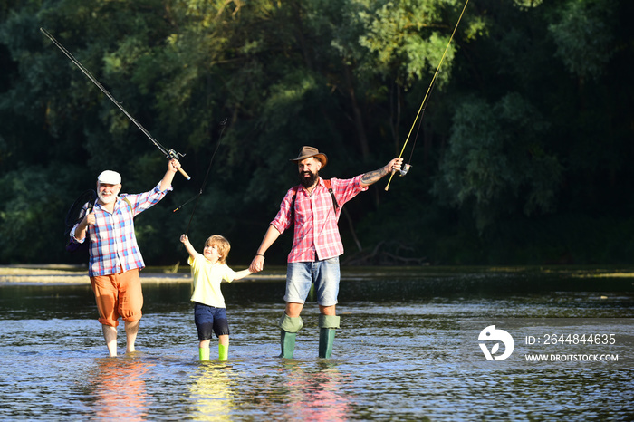 钓鱼者。家庭纽带。男孩与父亲和祖父在河的背景下在户外飞钓。