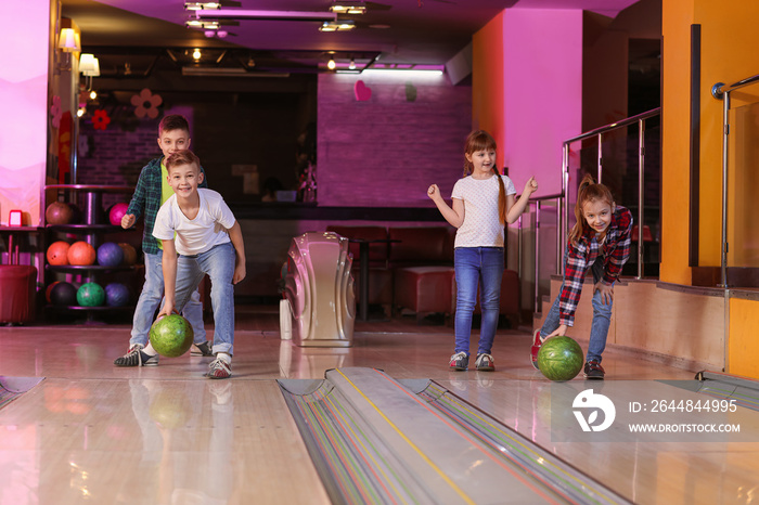 Little children playing bowling in club