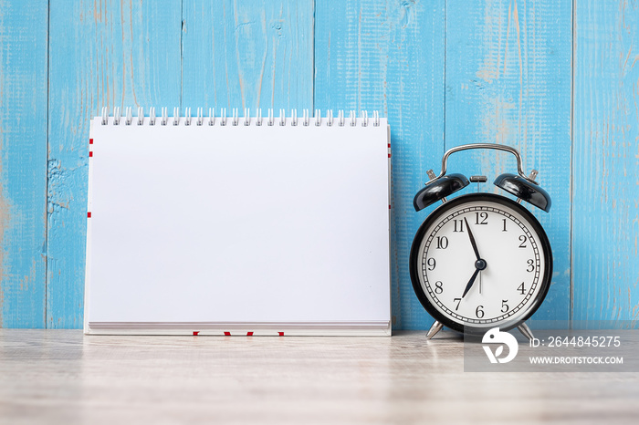 alarm clock with note paper on wooden table background and copy space for text. Activity, morning co