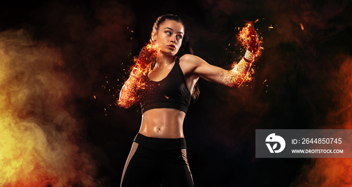 火灾中黑色背景的女拳击手。拳击和健身概念。